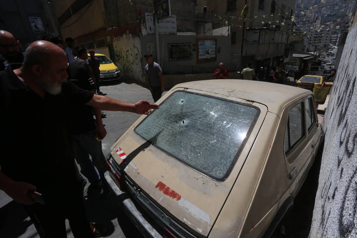 People look at the car that was hit by bullets following the death Palestinian man, shot directly in the chest, in the raid by Israeli forces on the Al-Ayn Refugee Camp in Nablus, occupied West Bank on July 26, 2023 [Nedal Eshtayah/Anadolu Agency]