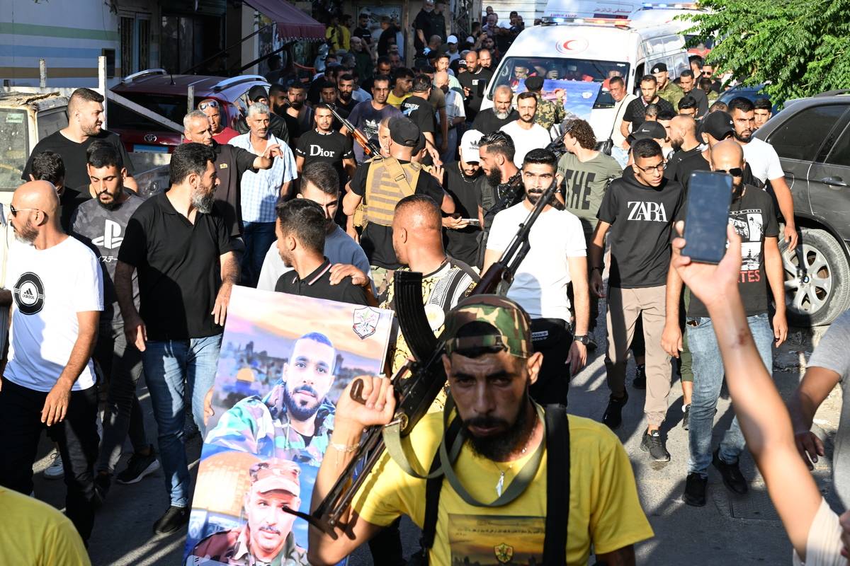 A man holds a poster among the people gathered for the funeral ceremony of Abu Sheref el-Armoushi, Fatah Movement member and 3 guards who were killed in clashes between two factions at the Palestinian refugee camp of Ain al-Helwa in Sidon, Lebanon on July 31, 2023 [Houssam Shbaro - Anadolu Agency]
