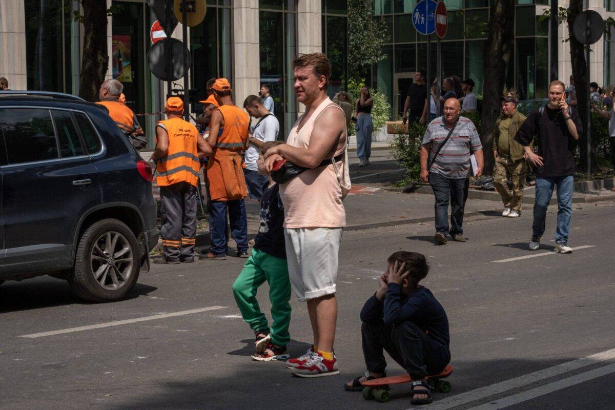 A man with children near a four-story residential building hit by a missile on July 6, 2023 in Lviv, Ukraine [Iva Sidash/Global Images Ukraine via Getty Images]