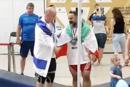 Mostafa Rajai (R) shakes hands with Maksim Svirsky (L) at the World Masters Championship in Poland [Screenshot/X]