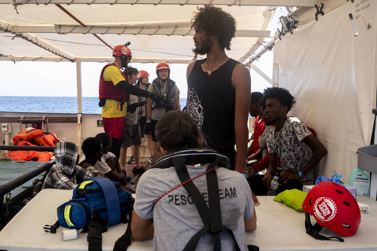 A nurse of the rescue team talks with a migrant after the migrants were rescued from the sea and taken on board in the Spanish NGO Open Arms rescue operation at the SAR Zone of Libya on August 02, 2023 [Valeria Ferraro - Anadolu Agency]