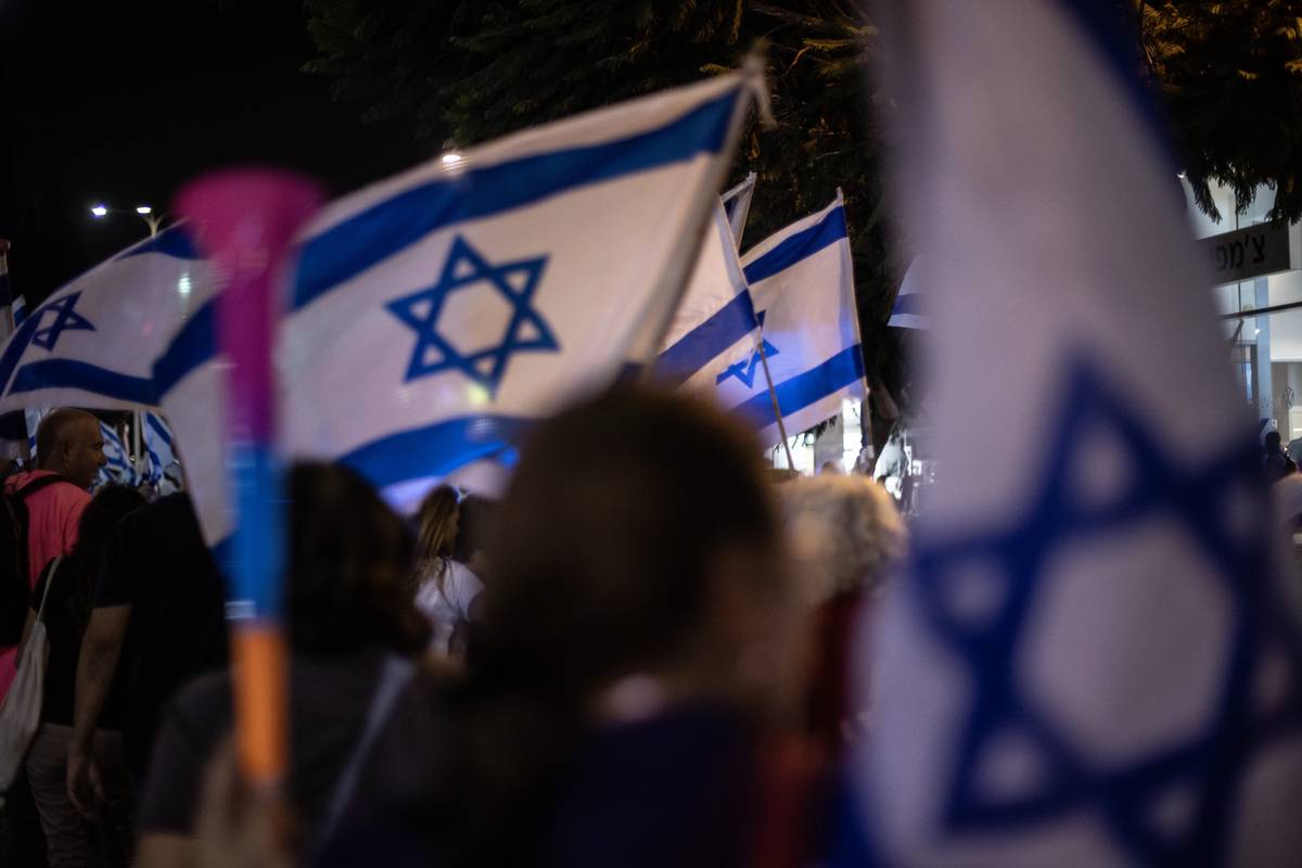 People, carrying flags, various banners and placards, gather to protest Prime Minister Benjamin Netanyahu's judicial reform in Tel Aviv, Israel on August 24, 2023 [Mostafa Alkharouf - Anadolu Agency]