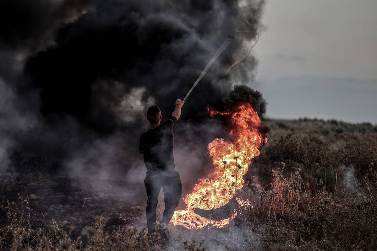 A Palestinian man throws a stone in response to Israeli forces intervention during the demonstration after Israeli forces attacked people who came to the Masjid al-Aqsa to perform Friday prayers at Israeli border in Gaza City, Gaza on August 25, 2023 [Ali Jadallah - Anadolu Agency]
