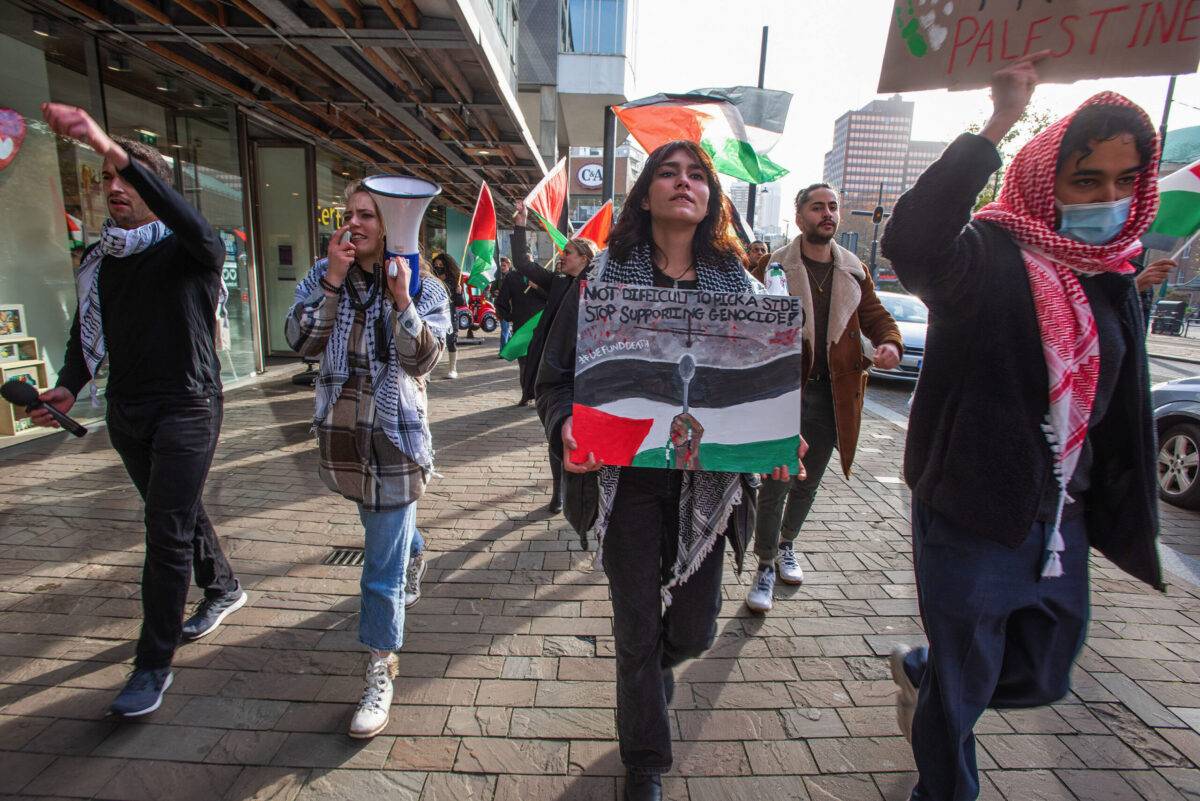 Pro-Palestinian protesters hold placards and flags during a demonstration to protest Dutch government-backed arms exhibition, hosting companies such as Elbit Systems in Rotterdam central station in February 2022 [Charles M Vella/SOPA Images/LightRocket via Getty Images]