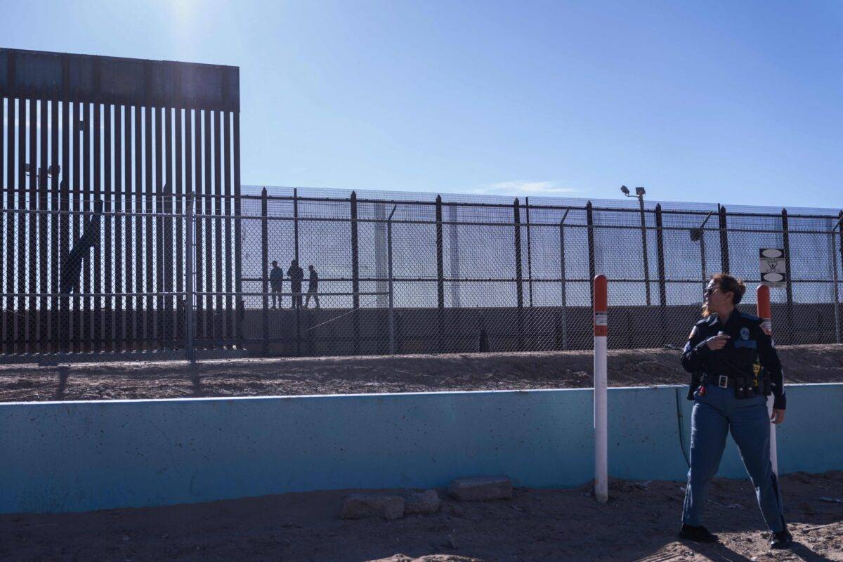 A law enforcement officer stands guard by a fence at the border with Mexico in El Paso, Texas, on December 22, 2022 ALLISON DINNER/AFP via Getty Images]