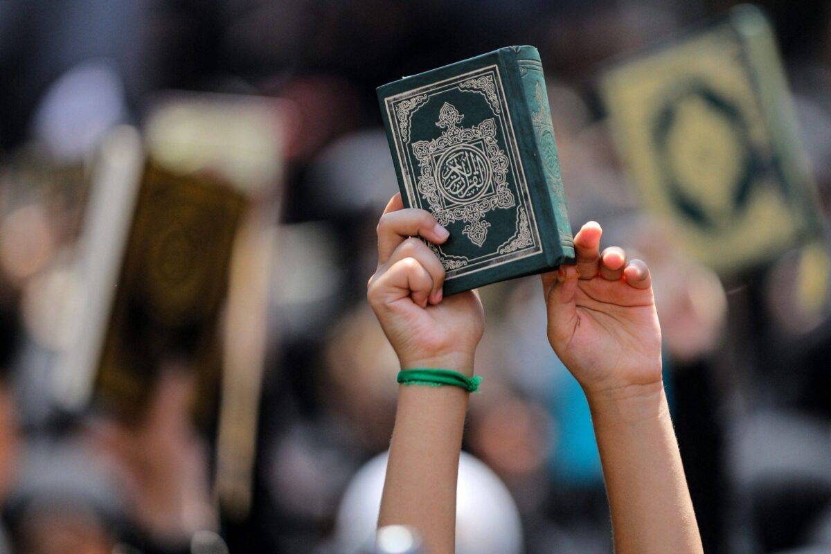 A child raises a copy of the Quran during a demonstration called for by the Lebanese Shiite Hezbollah movement, to denounce the burning of the Quran in Sweden, in the southern suburbs of Beirut on July 21, 2023 [IBRAHIM AMRO/AFP via Getty Images]
