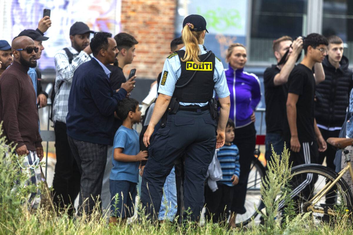 Muslims coming from Friday prayer watch the Quran being burnt on the opposite street from the mosque on July 28, 2023 in Copenhagen, Denmark [Ole Jensen/Getty Images]