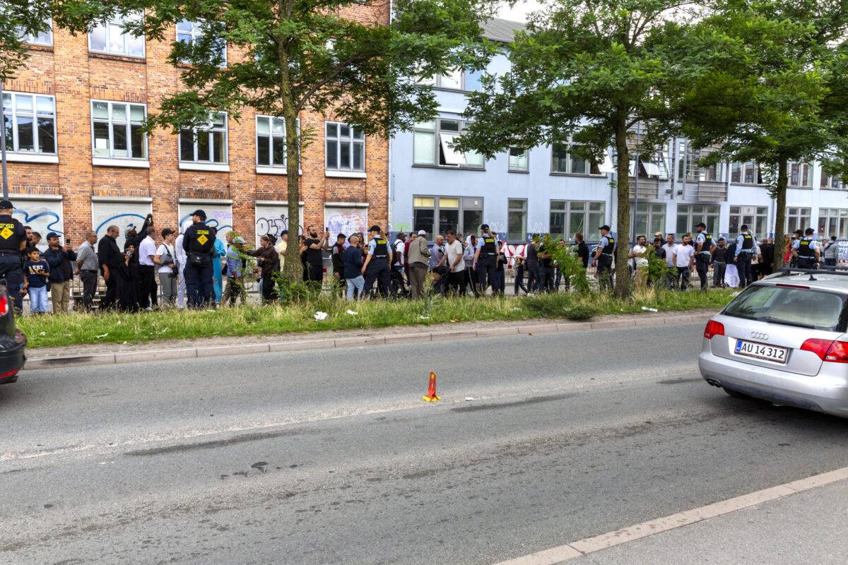 Muslims coming from Friday prayer watch the Quran being burnt on the opposite street from the mosque on July 28, 2023 in Copenhagen, Denmark [Ole Jensen/Getty Images]
