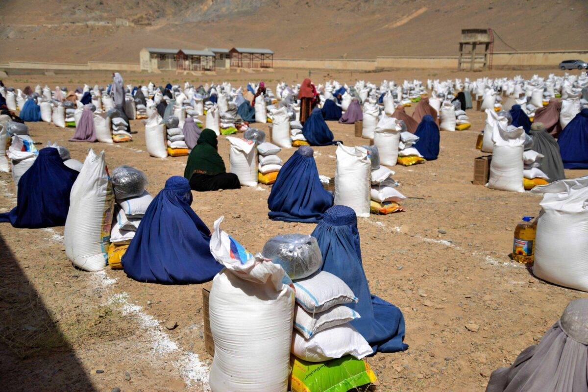 Afghan burqa-clad women receive food from foreign aid in Kandahar on August 10, 2023 [SANAULLAH SEIAM/AFP via Getty Images]