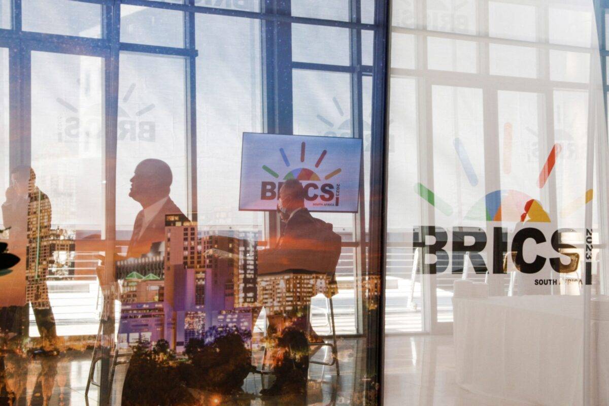 Delegates walk past the logos of the BRICS summit during the 2023 BRICS Summit in Johannesburg on August 23, 2023 [GIANLUIGI GUERCIA/POOL/AFP via Getty Images]