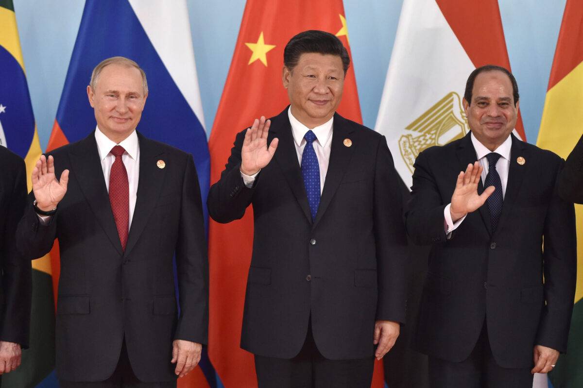 (L-R) Russian President Vladimir Putin, Chinese President Xi Jinping, Egypt's President Abdel-Fattah el-Sisi wave hands during the group photo session, a head of the Dialogue of Emerging Market and Developing Countries, on the sideline of the BRICS Summit [KENZABURO FUKUHARA/AFP via Getty Images]