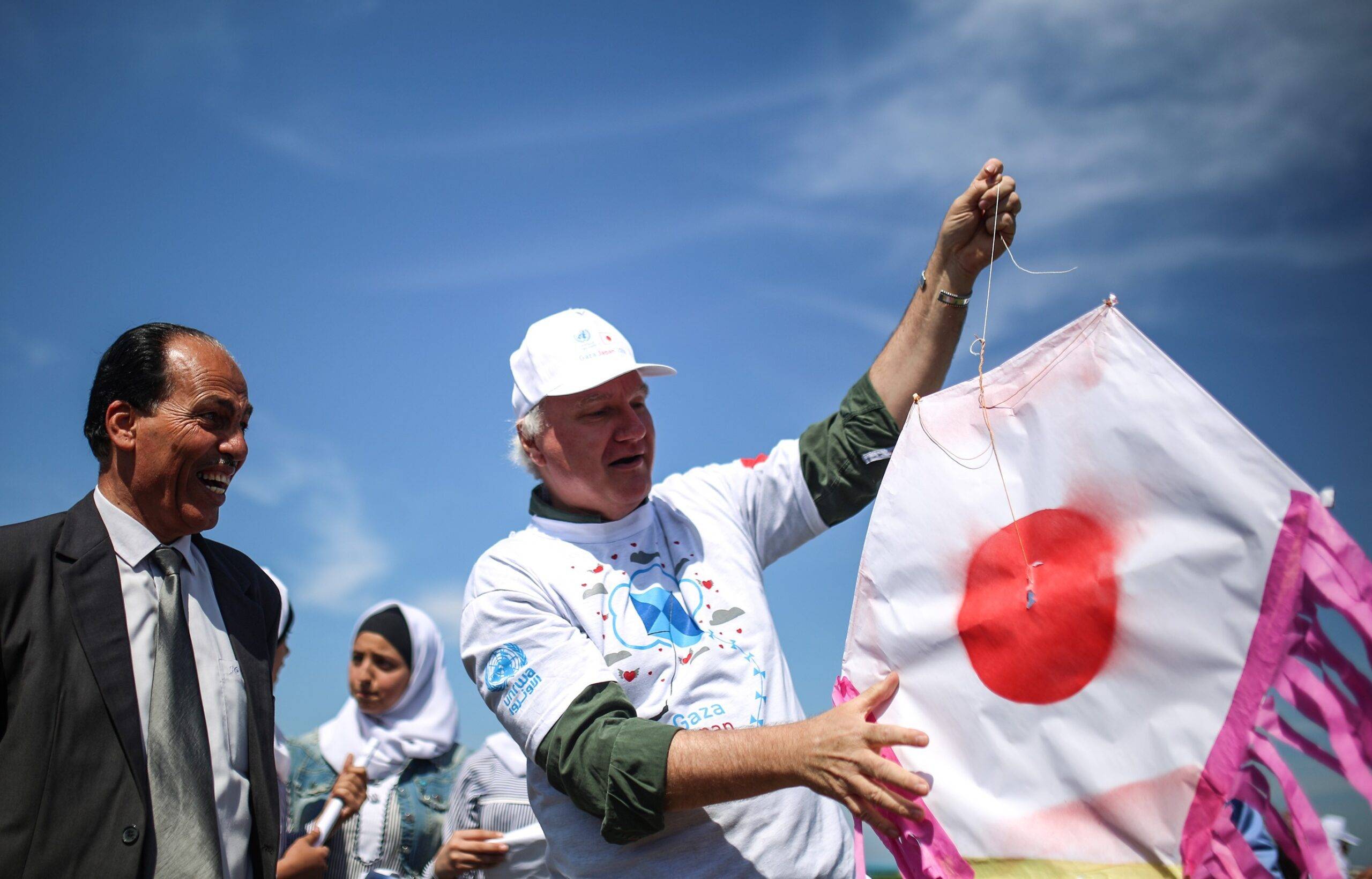 Director of Operations in Gaza of UNRWA, Matthias Schmale (R) holds a Japanese flag kite at an event organised by United Nations Relief and Works Agency for Palestine Refugees (UNRWA) on March 13, 2018 in Khan Yunis, Gaza [Mustafa Hassona/Anadolu Agency/Getty Images]