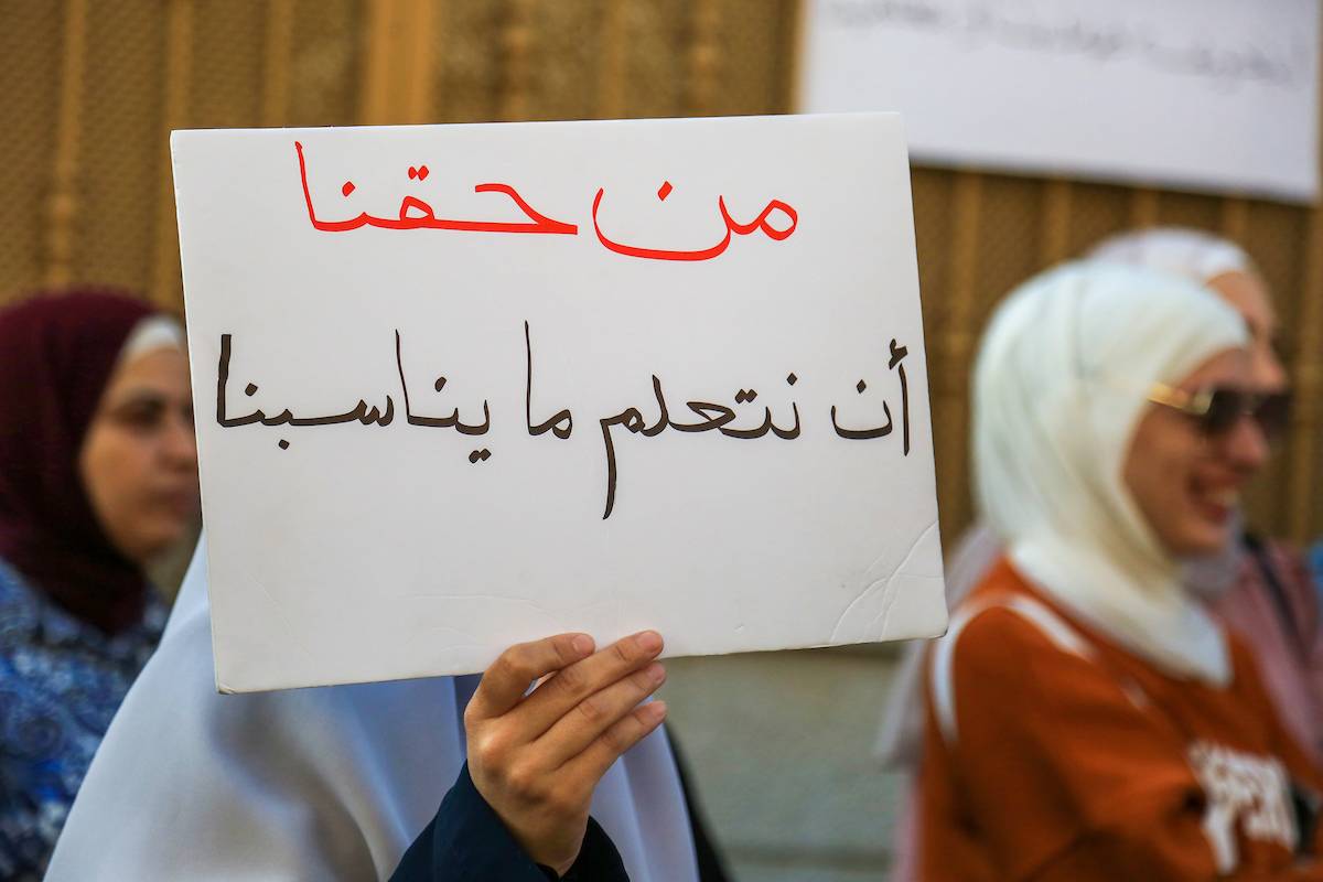 Palestinian parents of the students of al-Iman (Faith) school in the Jerusalem neighborhood of Beit Hanina hold placards during a protest against the Israeli attempts to impose a new curriculum, on October 27, 2022. [Saeed Qaq/Apaimages]