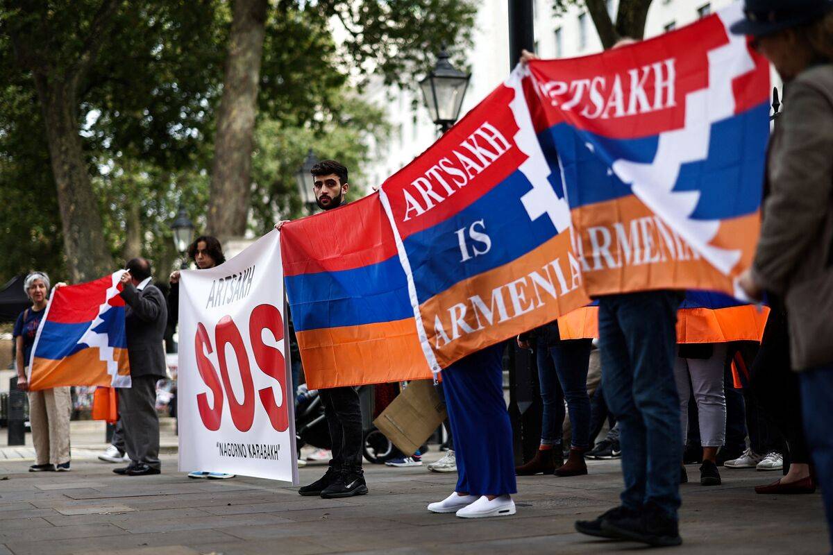Armenians hold placards and national flags during a demonstration outside Downing Street in London on September 30, 2023 to protest against Azerbaijan's offensive in Nagorno-Karabakh. [HENRY NICHOLLS/AFP via Getty Images]