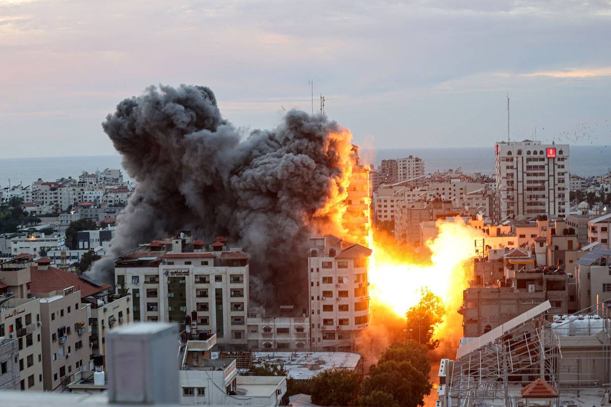 Smoke and flames rise after Israeli air forces targeting a shopping center in Gaza Strip, Gaza on October 07, 2023. [Mustafa Hassona - Anadolu Agency]