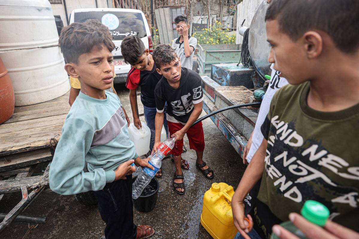 Palestinians fill water bottles and take them home as a UN report states that more than 2 million people struggle with water shortage, in Khan Younis, Gaza on October 14, 2023 [Mustafa Hassona - Anadolu Agency]