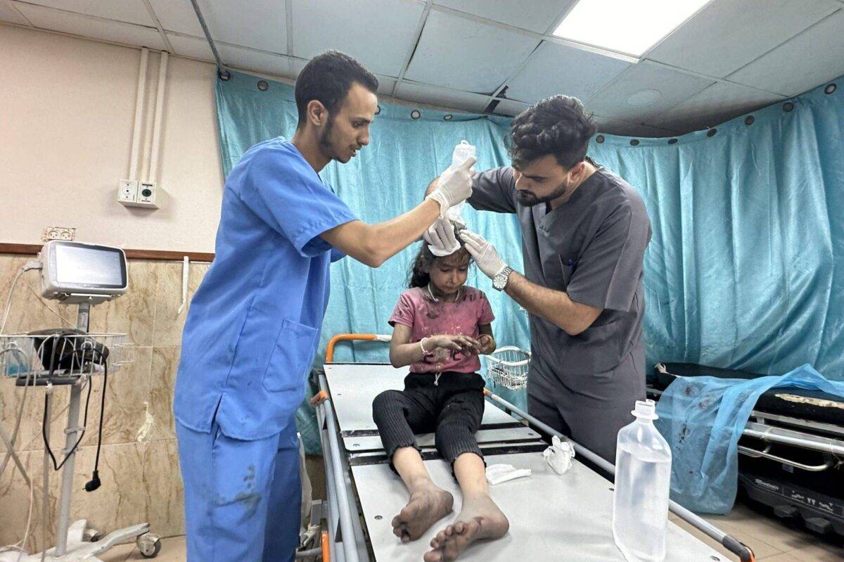 Doctors treat an injured child as a result of Israeli attacks at a hospital in Deir-Al-Balah, Gaza on October 14, 2023 [Doaa Albaz/Anadolu Agency]