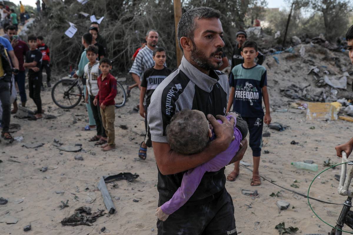 A man carries a dead baby pulled from rubble of destroyed house of a Palestinian family hit by an Israeli airstrike in Khan Yunis, Gaza on October 16, 2023. [Belal Khaled - Anadolu Agency]