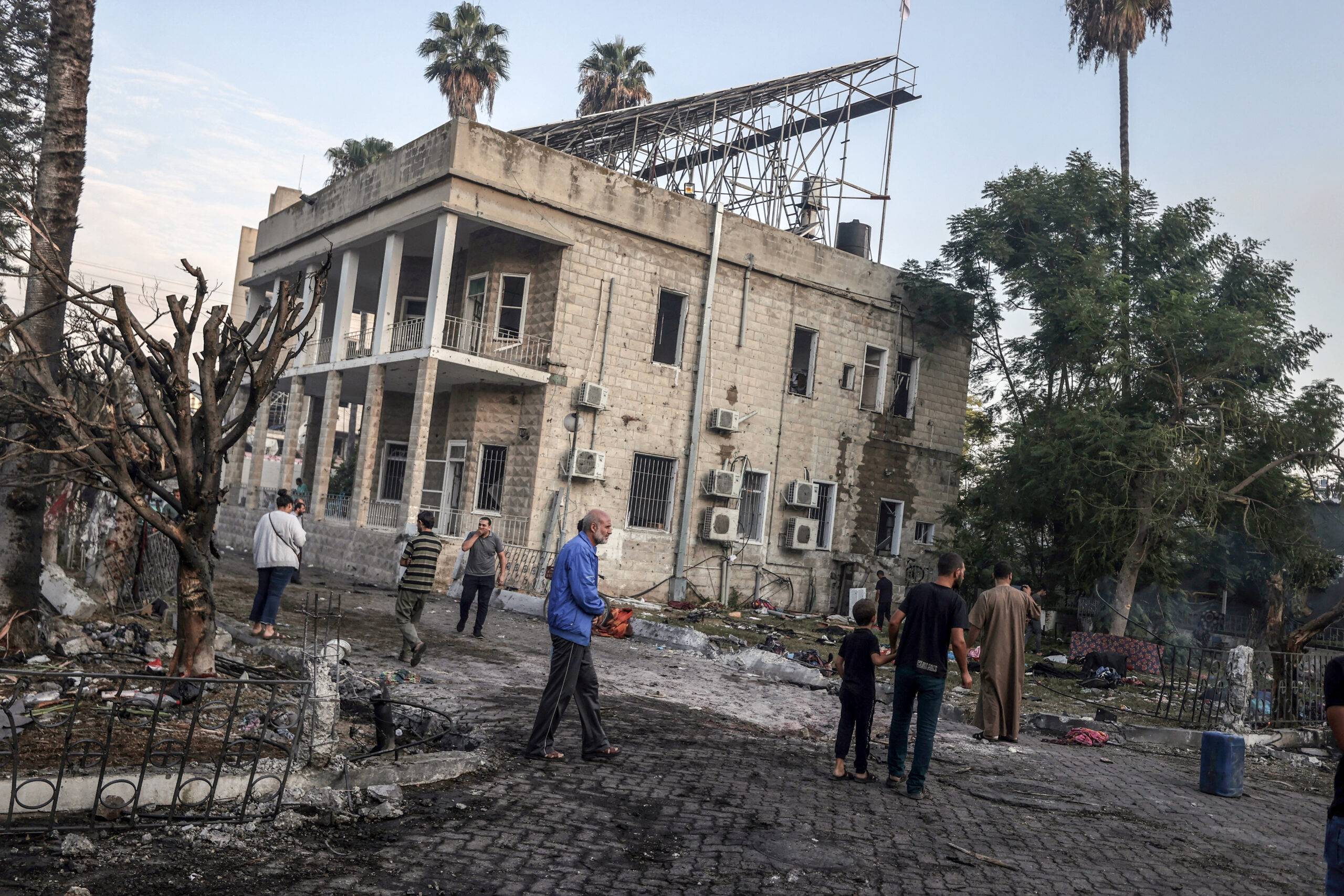 Civilians collect usable belongings amid wreckage of vehicles after Al-Ahli Baptist Hospital was hit in Gaza City, Gaza on October 18, 2023 [Ali Jadallah - Anadolu Agency]