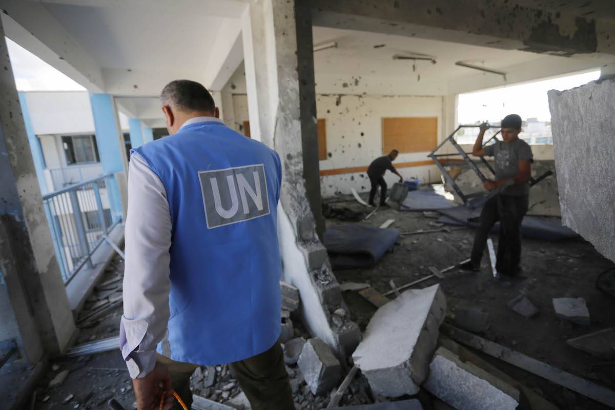 Palestinian children search for usable items in a destroyed school, run by the United Nations Relief and Works Agency for Palestine Refugees (UNRWA), after Israeli airstrikes at Al-Maghazi Refugee Camp in Deir al-Balah, Gaza on October 18, 2023. [Ashraf Amra - Anadolu Agency]