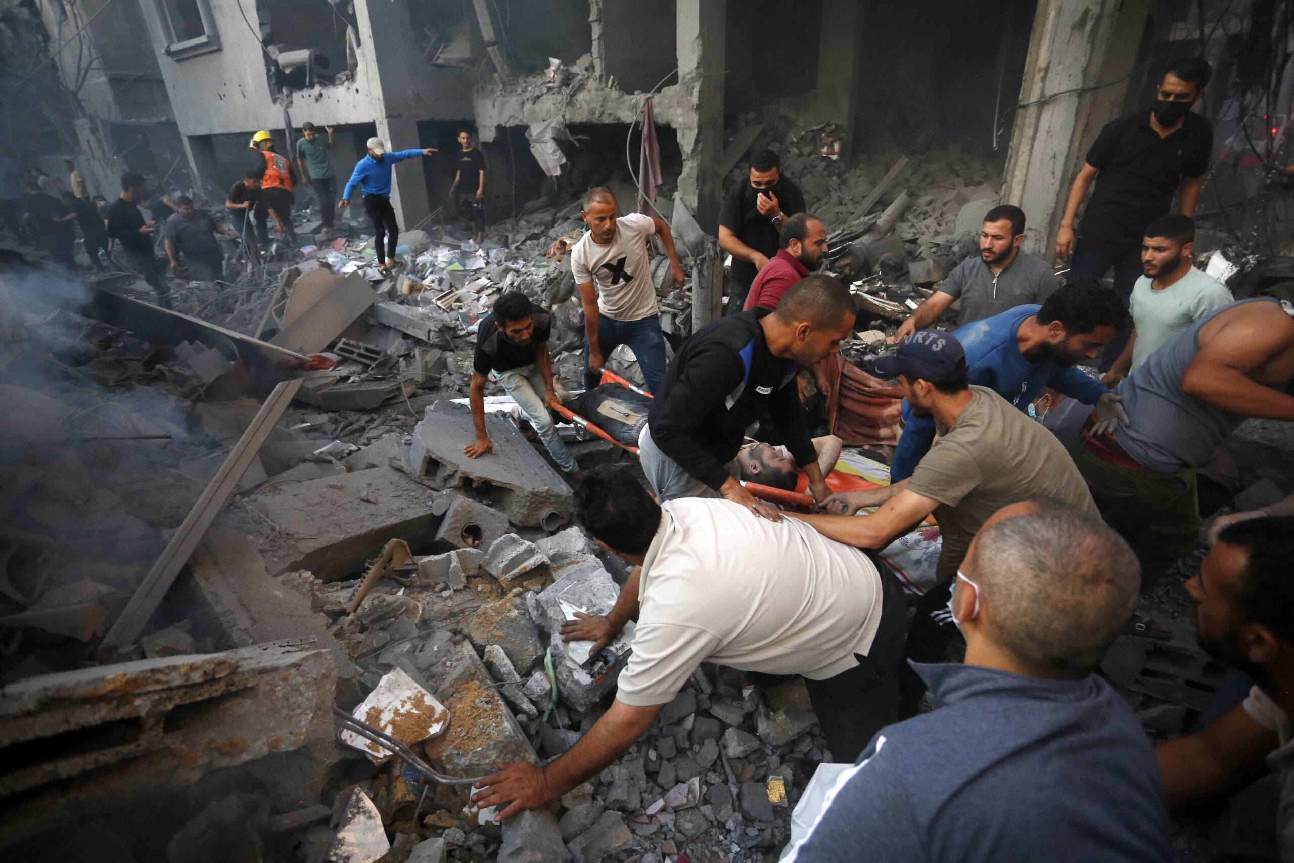 People carry an injured Palestinian man on a stretcher after the Israeli airstrikes in Deir al-Balah, Gaza on October 18, 2023 [Ashraf Amra/Anadolu Agency]