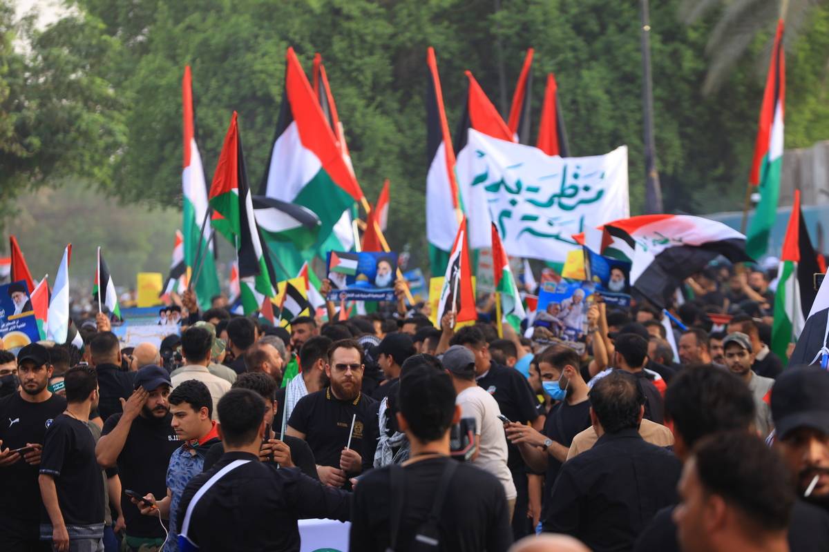 Supporters of Popular Mobilization Forces and Iraqi citizens march with Palestinian flags as they protest against Israeli airstikes on Gaza in Baghdad, Iraq on October 20, 2023. [Murtadha Al-Sudani - Anadolu Agency]