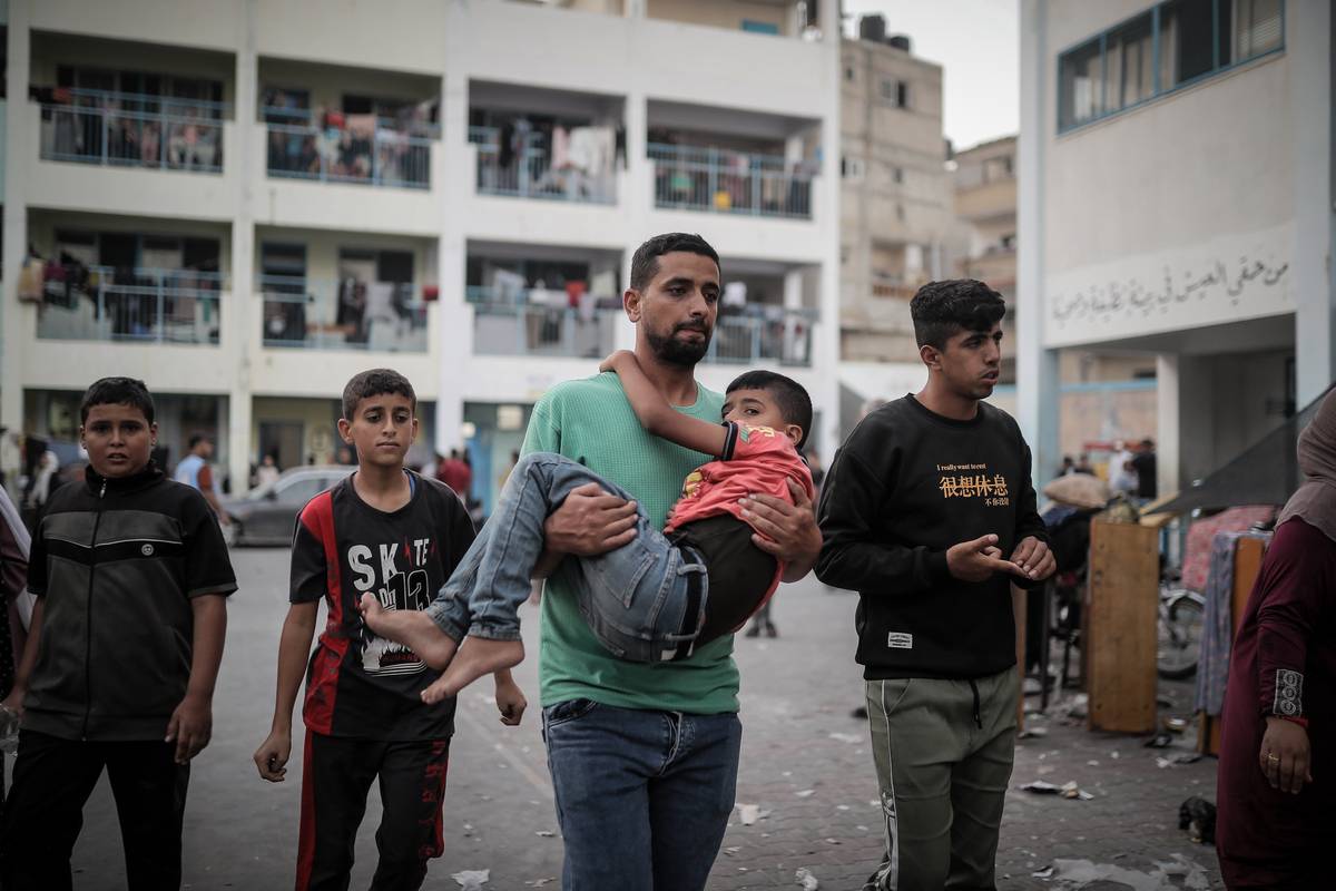 Palestinians taking refuge in a UNRWA school panic after an Israeli airstrike hits a house across the road in Khan Yunis, Gaza on October 21, 2023. [Belal Khaled - Anadolu Agency]