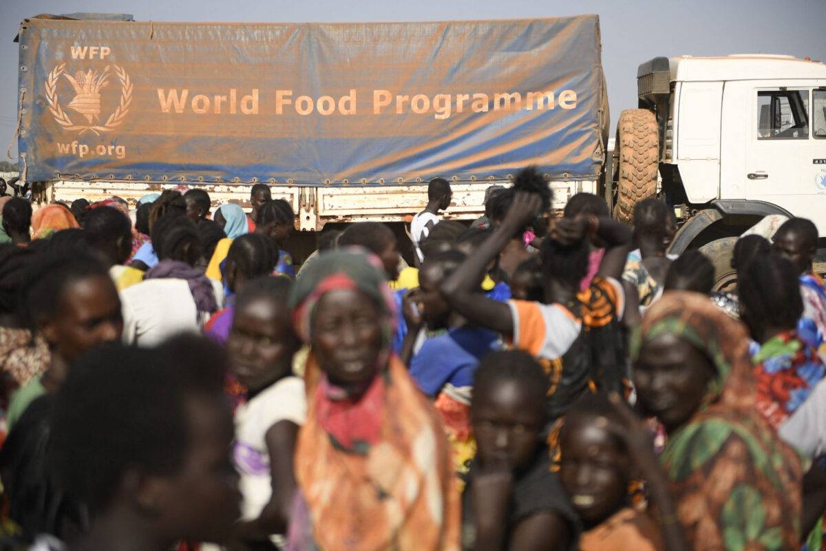 Internally displaced women wait for their food ration during a food distribution next to a World Food Programme (WFP) truck in Bentiu on February 7, 2023 [SIMON MAINA/AFP via Getty Images]