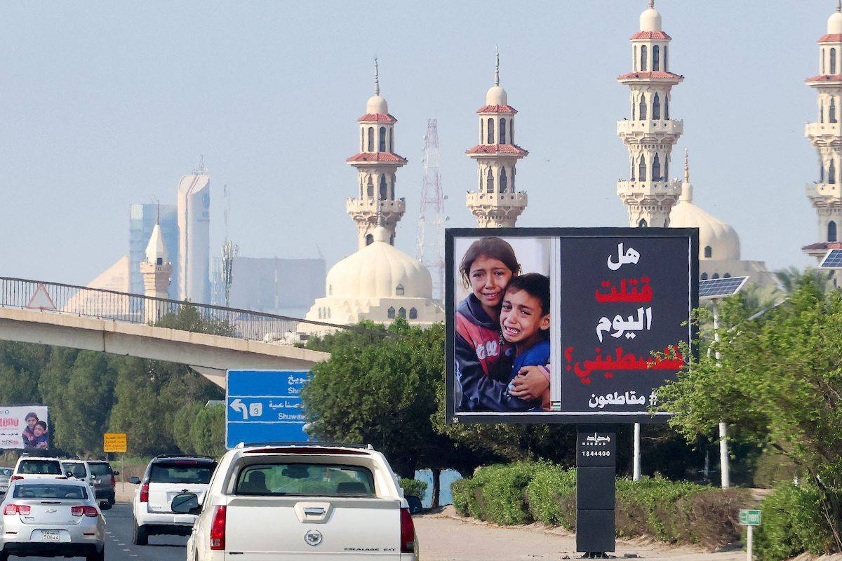 Cars drive past a billboard bearing a picture of Palestinian children and an inscription in Arabic that reads "Have you killed a Palestinian today ? #boycott" in Kuwait City on October 26, 2023, as battles between Israel and the Palestinian Hamas movement continue. [YASSER AL-ZAYYAT/AFP via Getty Images]