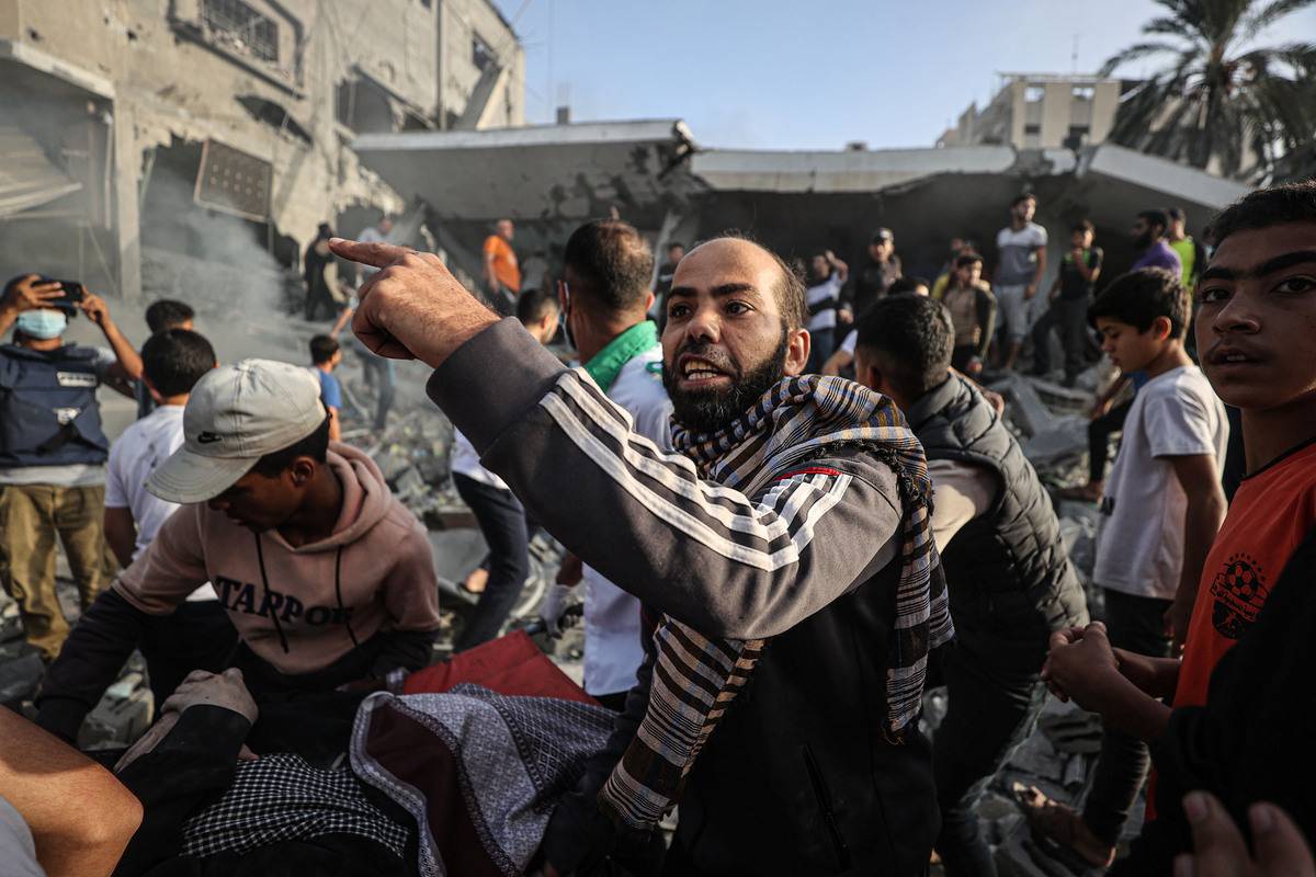 Civil defense teams and local people carry a person who was rescued alive under the rubble of the destroyed building belonging to Al Astal family as Israeli attacks continue on the 32nd day, in Khan Yunis, Gaza on November 07, 2023 [Mustafa Hassona - Anadolu Agency]