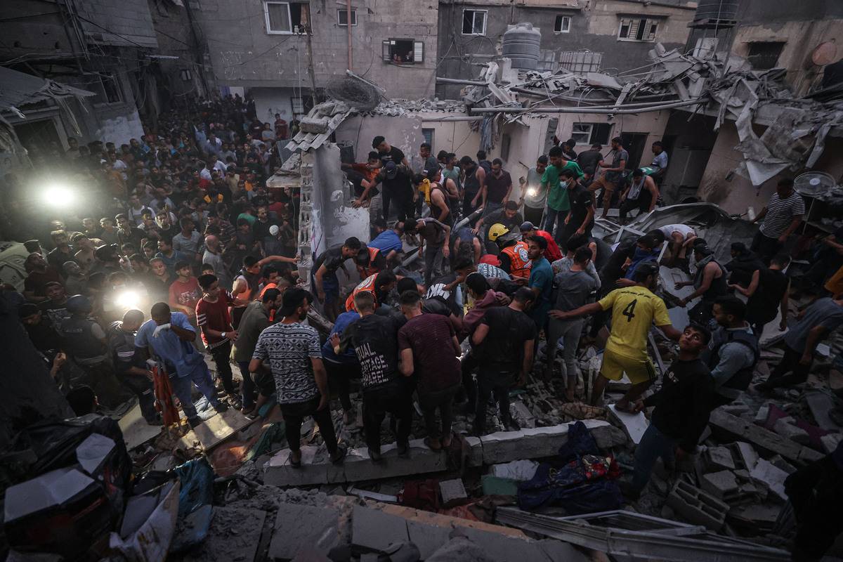 Civil defense teams and civilians conduct a search and rescue operation under the rubbles of demolished buildings after an Israeli attack hits Hamdan family's residence in Khan Yunis, Gaza on November 13, 2023 [Mustafa Hassona - Anadolu Agency]