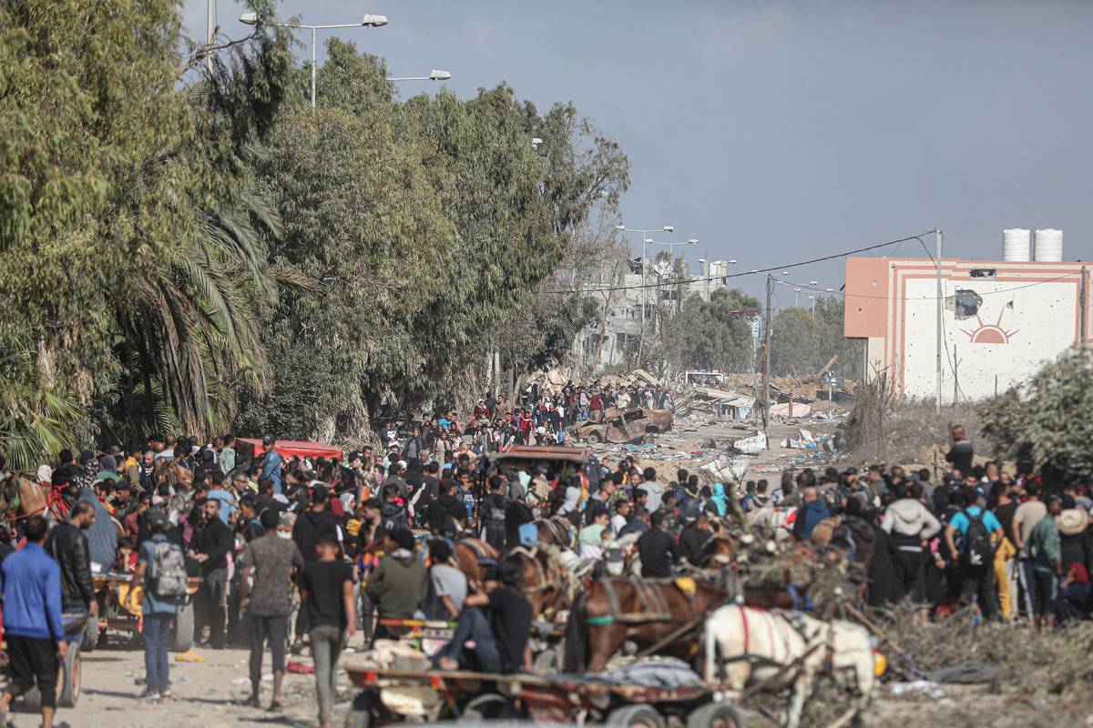 Palestinians in northern part of the Gaza migrate to the southern parts of the Gaza Strip passing through Israeli military vehicles and tanks as the Israeli attacks continue in Gaza City, Gaza on November 18, 2023 [Mustafa Hassona/Anadolu Agency]