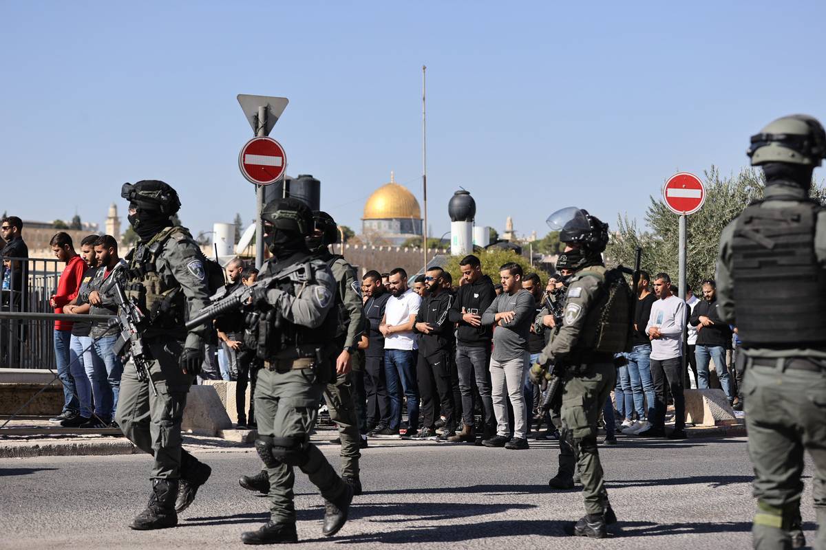 Israeli forces take security measures as Muslims perform Friday prayers on the street in Ras Al-Amud neighborhood, after Israeli authorities barred Palestinians from entering the Al-Aqsa Mosque in East Jerusalem on November 24, 2023. [Mostafa Alkharouf - Anadolu Agency]