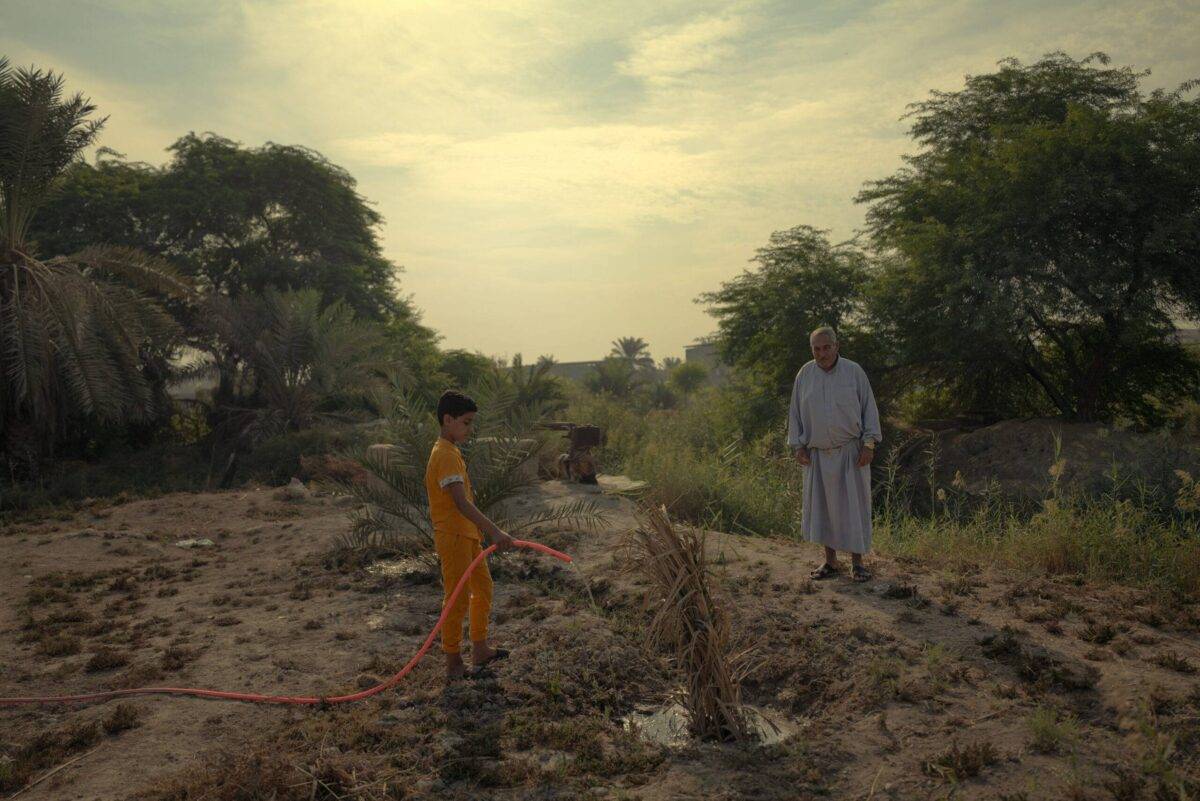 Ahmed, 14, with his father in the land that the family used to cultivate before the drought in Abu al-Khaseeb, Basra Governorate, Iraq [Emily Garthwaite/Save the Children]