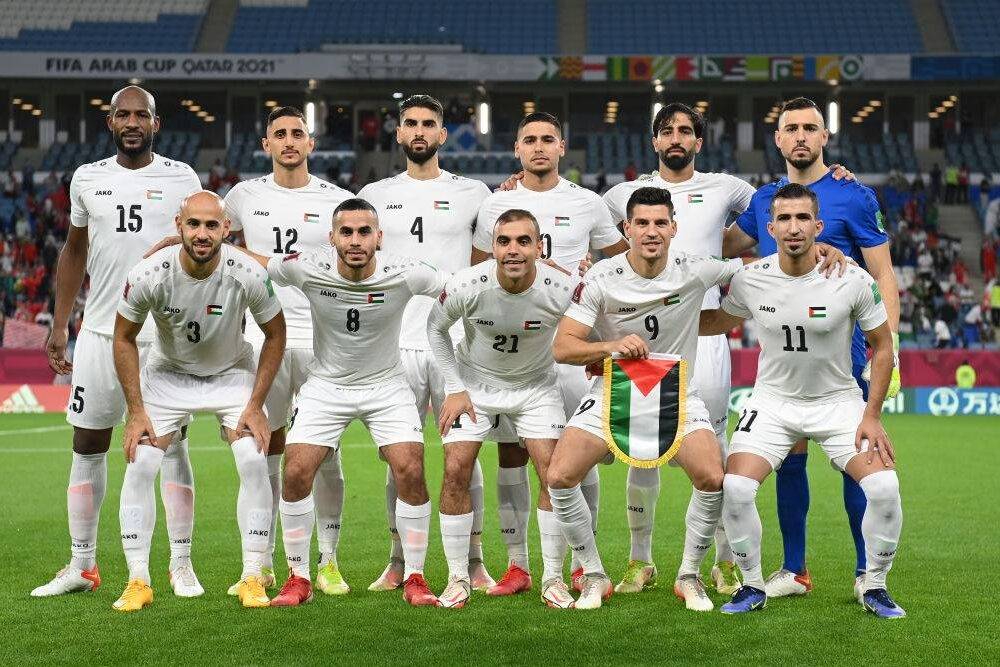 Palestine players pose for a team photo on pitch prior to the FIFA Arab Cup Qatar 2021 Group C match between Morocco and Palestine at Al Janoub Stadium on December 01, 2021 in Al Wakrah, Qatar [Photo by Michael Regan - FIFA/FIFA via Getty Images]