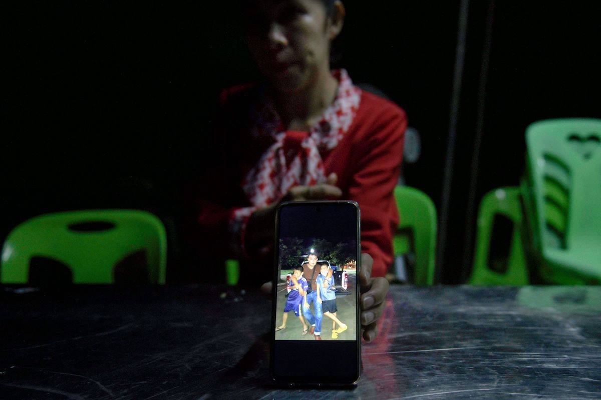 In this picture taken on October 13, 2023, Kanyarat Suriyasri, the wife of Thai worker Owat Suriyasri who is being held hostage by Hamas in Gaza, shows a picture of him and their two children in Kantharlak in Thailand's northeast Si Sa Ket province. [AMAURY PAUL/AFP via Getty Images]