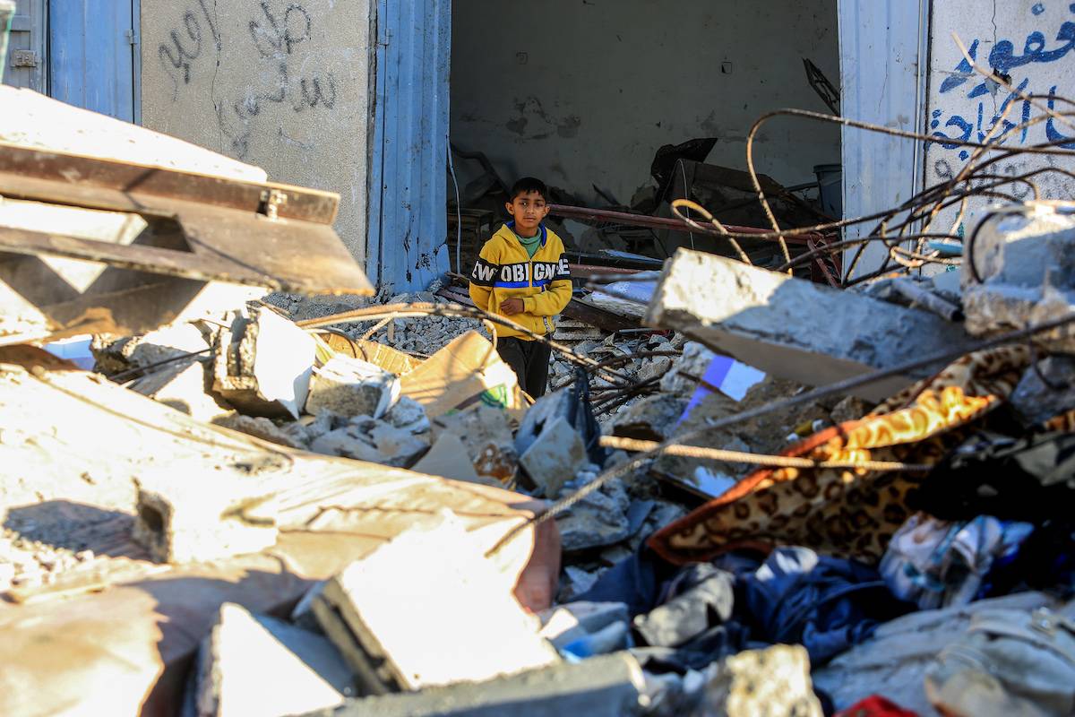 A child is seen as residents conduct a search and rescue operation among the destroyed buildings after Israeli attacks hit the apartment belonging to the Azuum family in Rafah, Gaza on December 03, 2023. [Abed Rahim Khatib - Anadolu Agency]