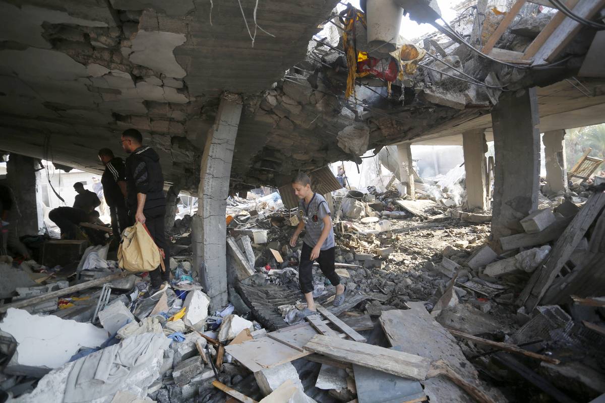 Palestinians search for their belongings amongst the rubble of buildings destroyed by Israeli attacks in Deir al Balah, Gaza on December 04, 2023 [Ashraf Amra/Anadolu Agency )