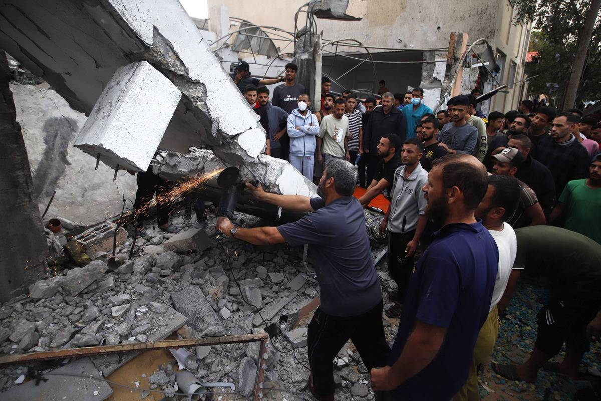 Residents and civil defense teams conduct a search and rescue operation around the rubble of the building that collapsed following an Israeli attack on house belonging to the Abu Saleh in Khan Yunis, Gaza on December 7, 2023. [Ramez Habboud - Anadolu Agency]