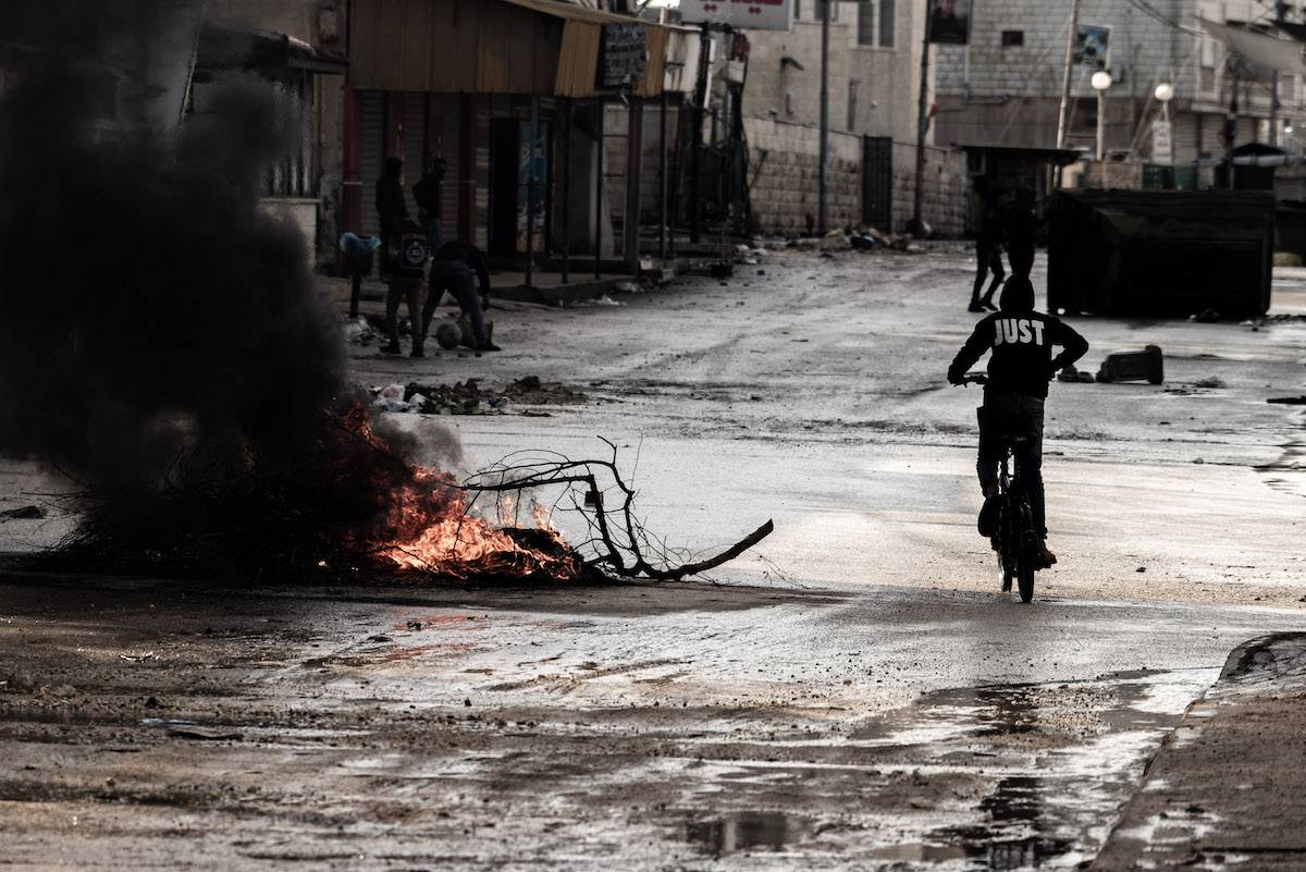 Israeli soldiers clash with Palestinians at the site where Israeli forces bombed 3 houses, killed 8 Palestinians, and injured others during a raid in Jenin, West Bank on December 13, 2023. [Vincenzo Circosta - Anadolu Agency]