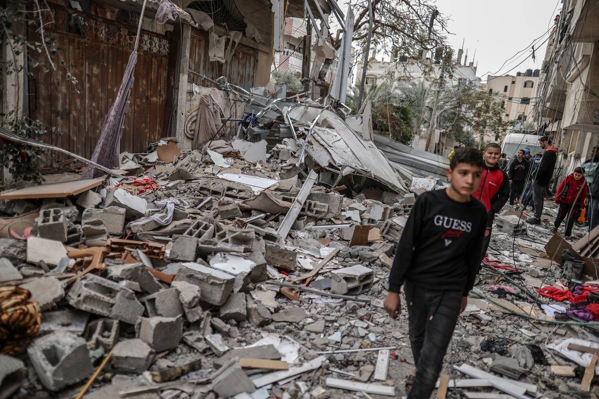 Residents inspect the rubble of the building following an Israeli attack at the Nuseirat refugee camp in Deir al-Balah, Gaza on December 23, 2023 [Ali Jadallah/Anadolu Agency]