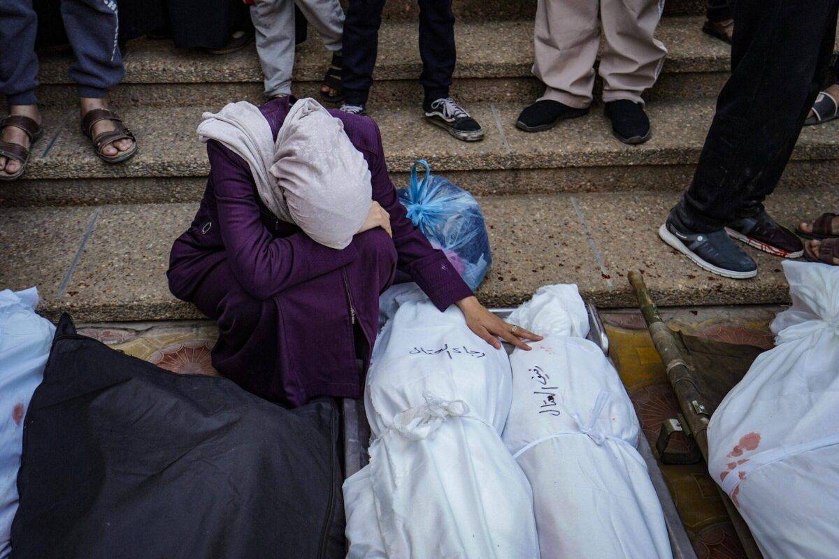 A Palestinian women, who lost her relative during the Israeli attacks on a building, mourns near the body in Khan Yunis, Gaza on December 26, 2023 [Belal Khaled/Anadolu Agency]