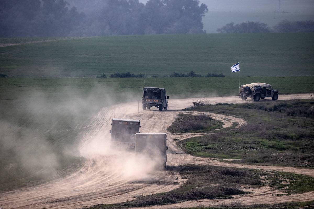 Israeli military vehicles are seen from Be'eri village as Israeli military mobility continues in Gaza on December 28, 2023. [Mostafa Alkharouf - Anadolu Agency]