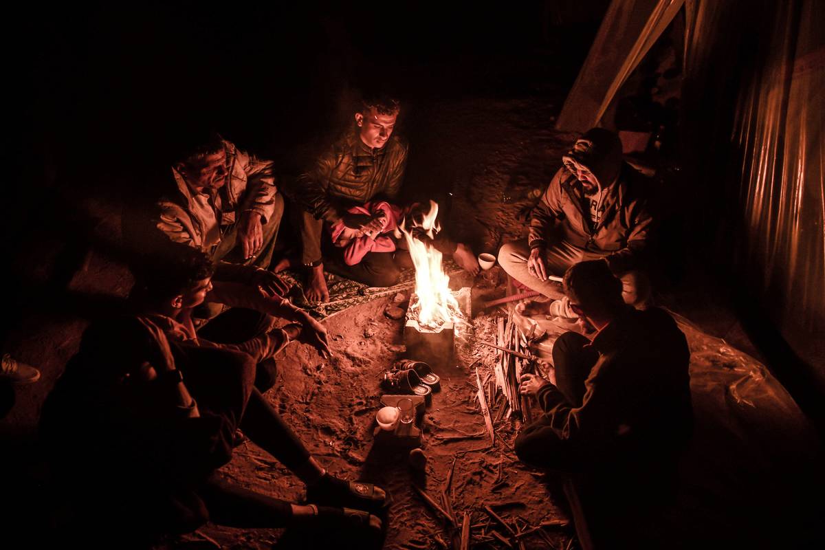 Palestinians who fled their homes due to the ongoing Israeli attacks are seen trying to continue their lives in makeshift tents and lighting fires to keep warm during the cold weather in Rafah, Gaza on December 31, 2023 [Abed Zagout - Anadolu Agency]