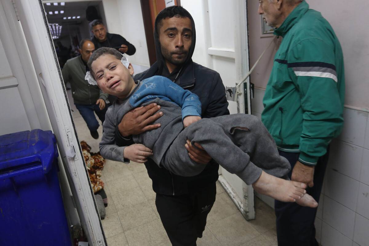 A Palestinian man carries an injured boy as a result of Israeli attacks to Al-Aqsa Martyrs Hospital for medical treatment while the attacks carried out by the Israeli army against the Gaza Strip continue in Deir al Balah, Gaza on January 05, 2024 [Ashraf Amra/Anadolu Agency]