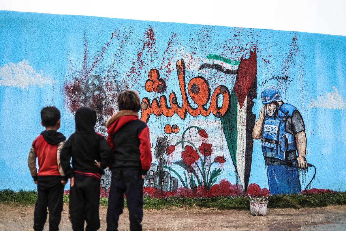 Syrian graffiti artist Aziz Esmer paints the Al Jazeera correspondent Vail ed-Dahduh, who lost his son Hamza in Israeli attacks on Gaza, and the Palestinian flag on a school wall to show solidarity in Idlib, Syria on January 10, 2024. [İzettin Kasım - Anadolu Agency]