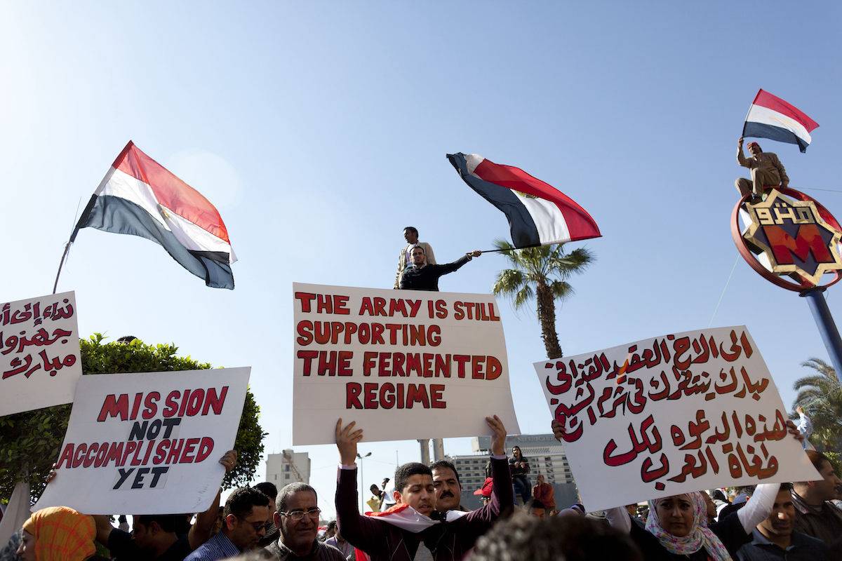People hold up signs during a rally at Tahrir Square on February 18, 2011 in Cairo, Egypt. [Carsten Koall/Getty Images]