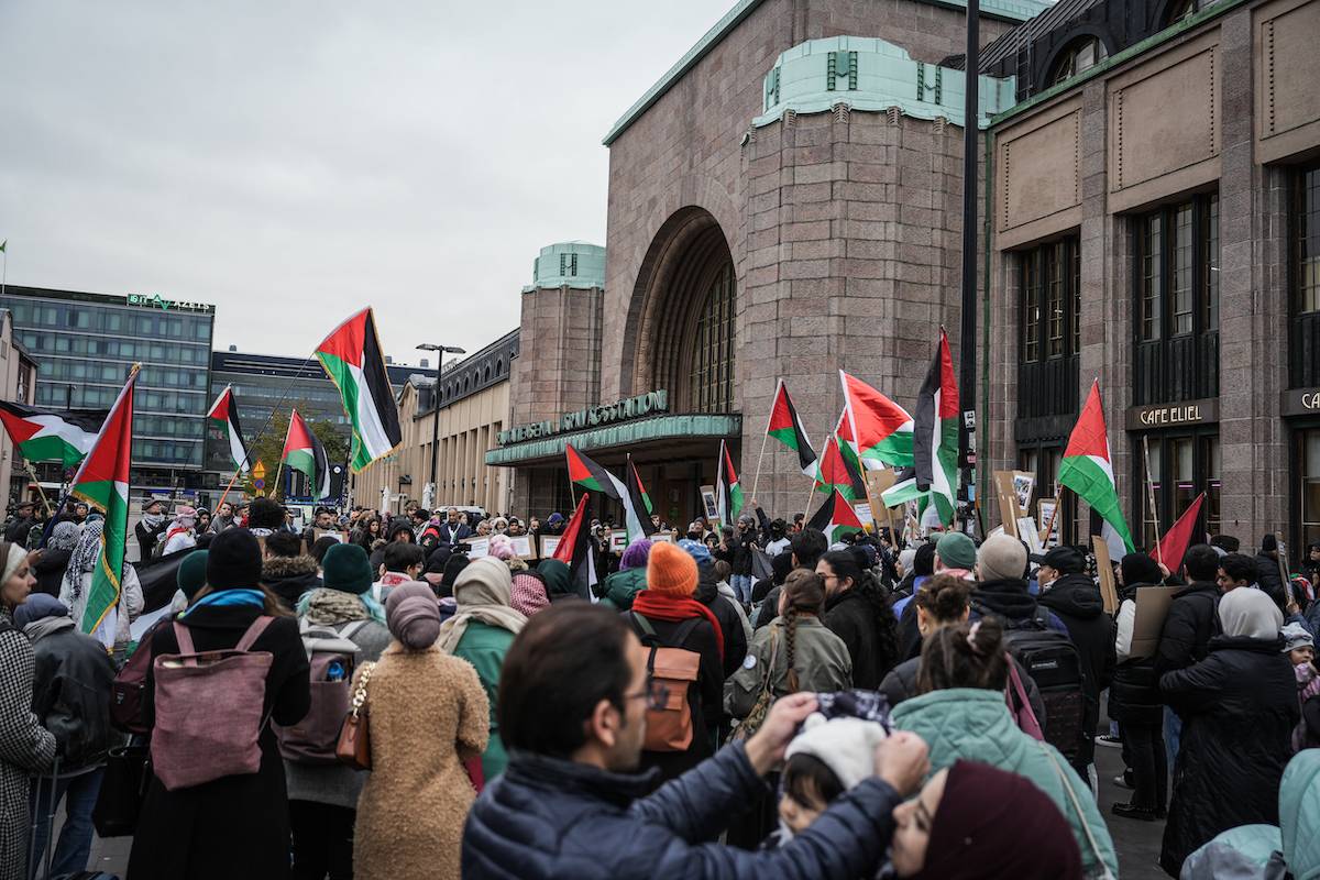 People carrying the Palestinian flag and banners gather in front of the central train station to protest against yesterday's bombing of Al-Ahli Baptist Hospital, on October 18, 2023, in Helsinki, Finland. [Alessandro Rampazzo/Anadolu via Getty Images]