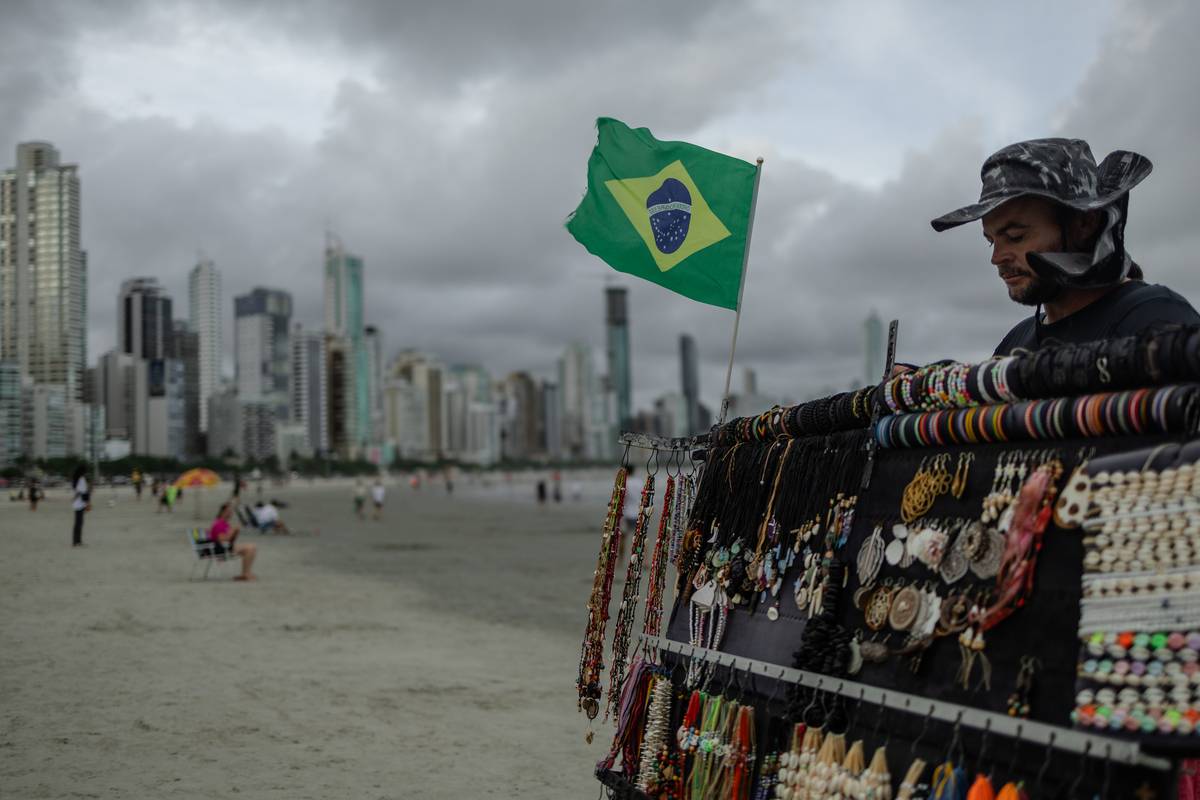 A vendor sells jewelry at a beach in Balneario Camboriu, Brazil, on Dec. 13, 2023. [Photographer: Maira Erlich/Bloomberg via Getty Images]