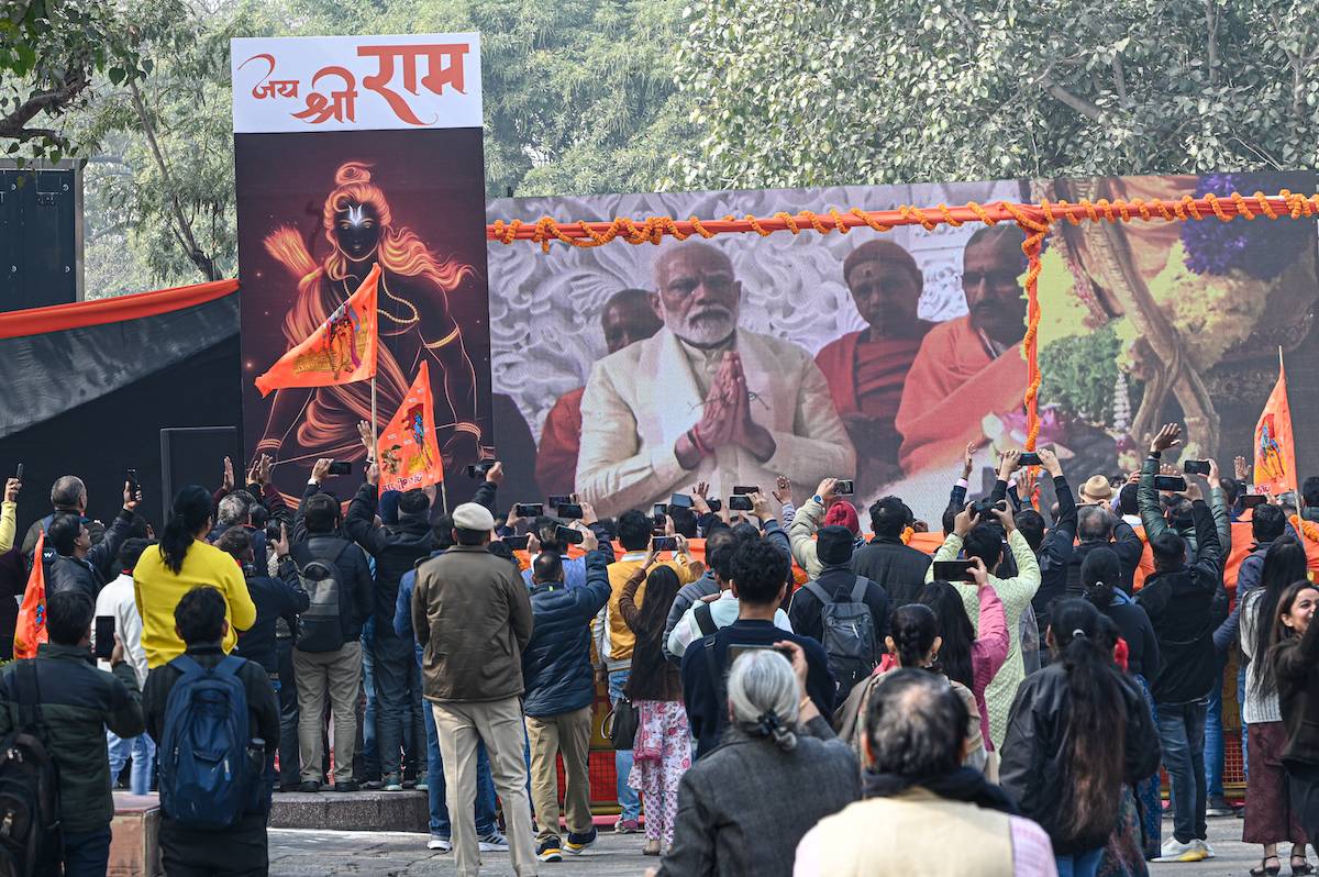 Pedestrians watch as a screen broadcasts footage of an inauguration ceremony for the Ram Temple in Ayodhya, attended by Prime Minister Narendra Modi, at a public venue in New Delhi, India, on Monday, Jan. 22, 2024. [Prakash Singh/Bloomberg via Getty Images]